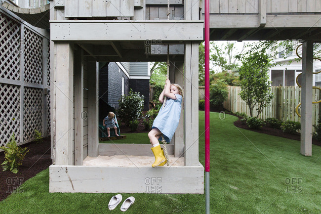 Girl Swinging On Rope At Playground In Backyard Stock Photo Offset