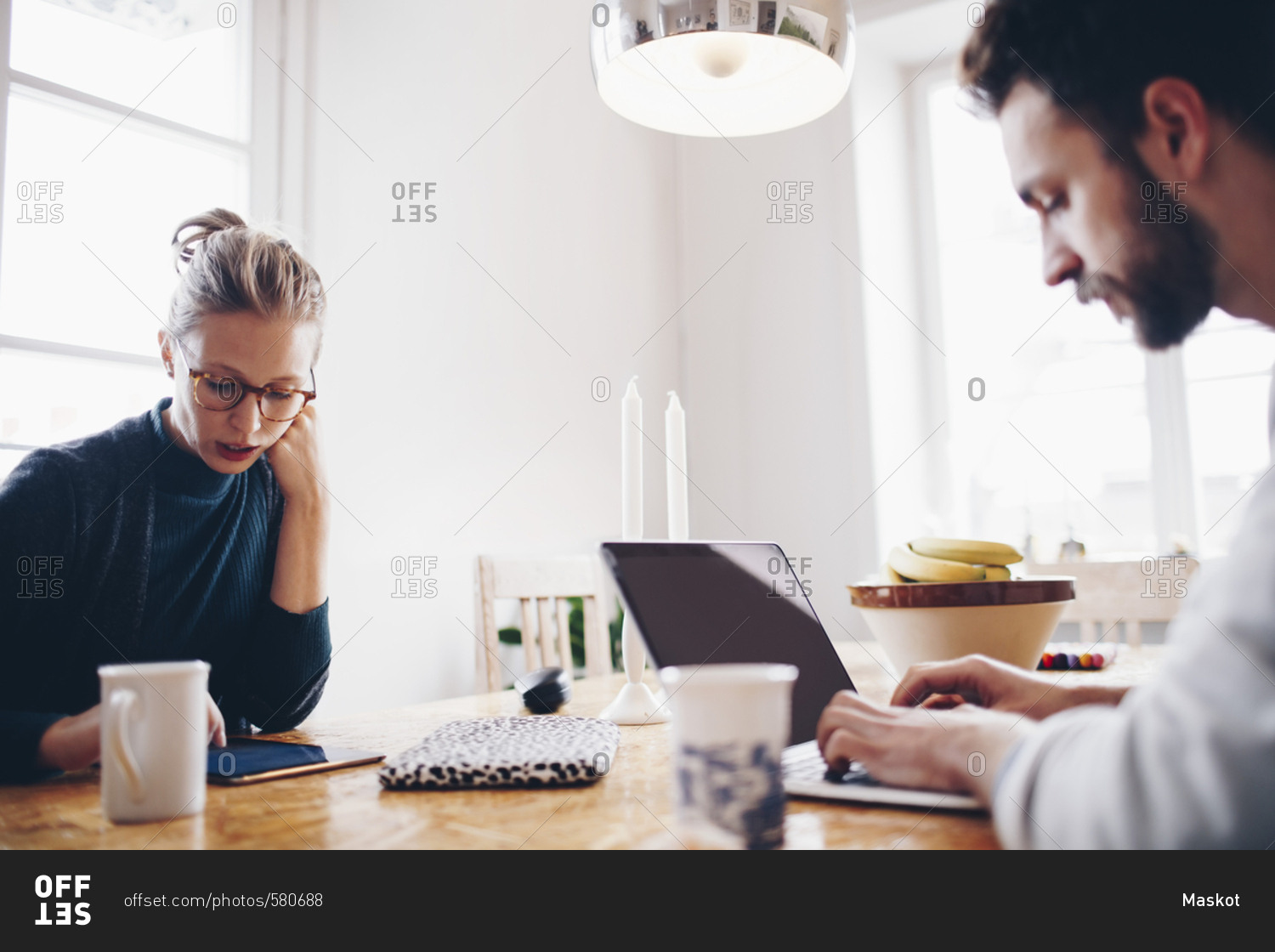 Couple using technologies at dining table while working from home