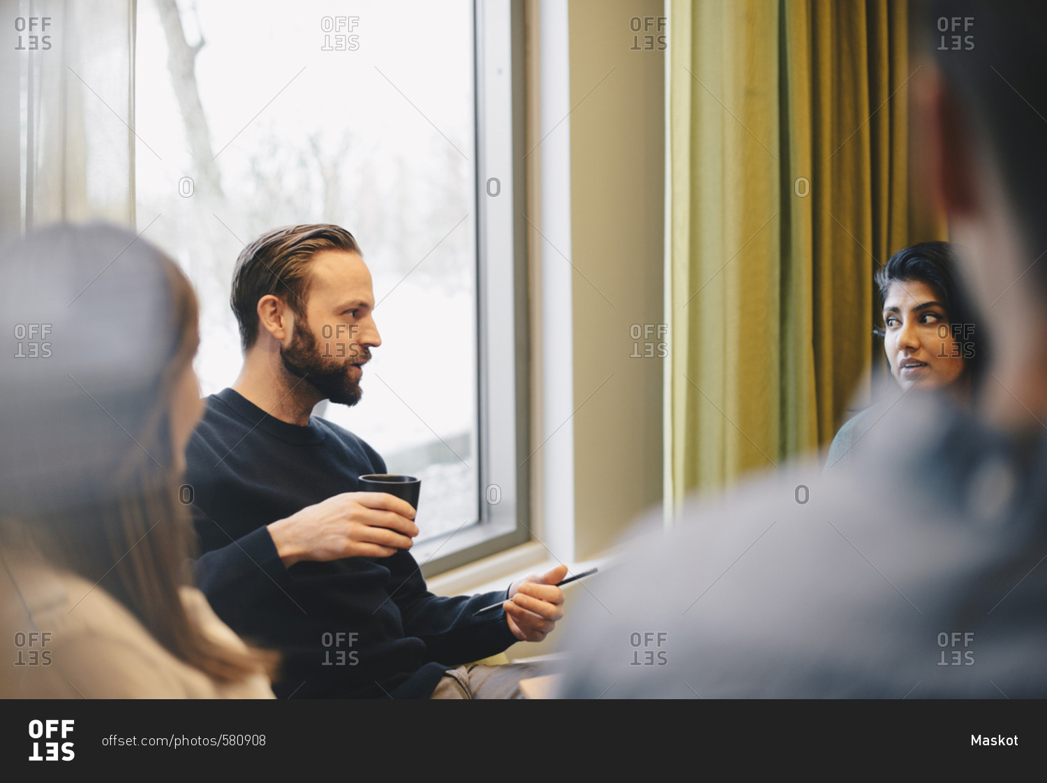 Confident businessman discussing with colleagues in board room meeting