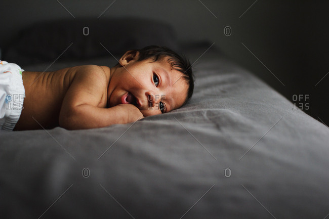 Baby lying awake on a bed