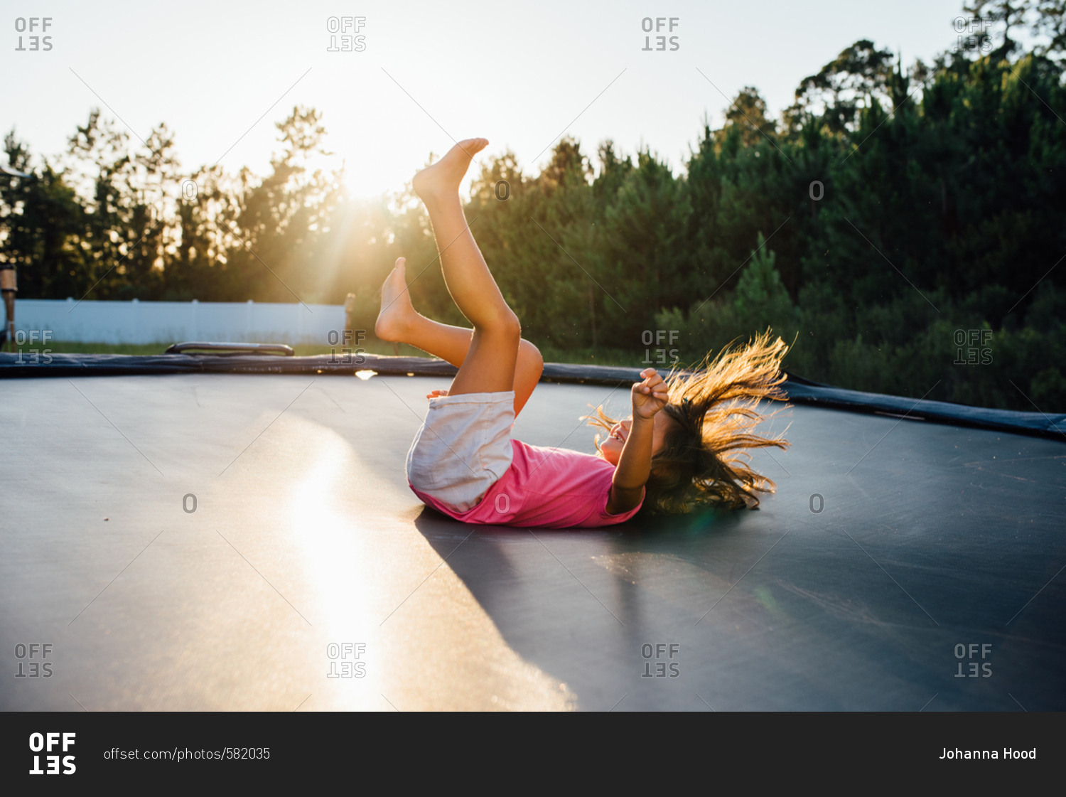 Girl landing on her back after doing a flip on trampoline