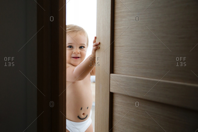 Happy Toddler Looking Through Door Stock Photo Offset