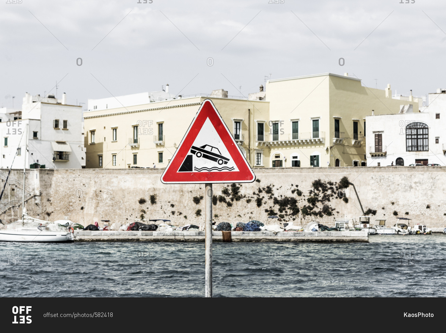 Street sign near the port, danger: car falling in water with danger road sign warning of car falling off bank