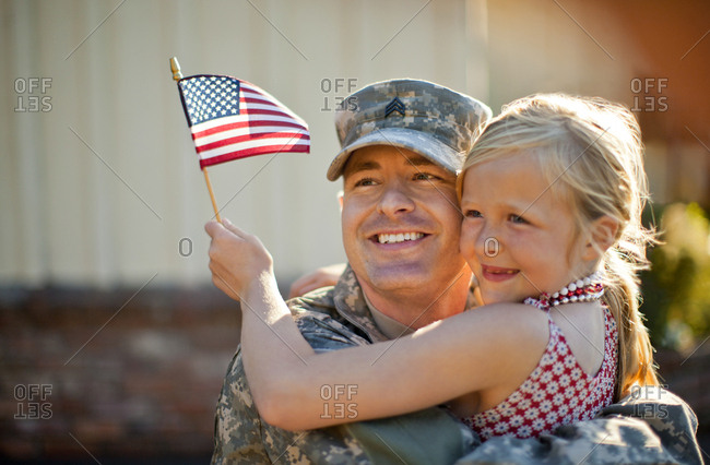 A returned American solider hugging his young daughter