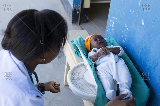 Nurse weighing baby in a clinic in Kenya, Africa
