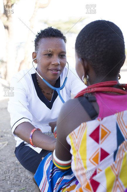 Nurse examining woman with stethoscope in Samburu village in Kenya, Africa