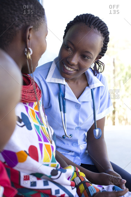 Nurse examining Mother and daughter in a clinic in Kenya, Africa