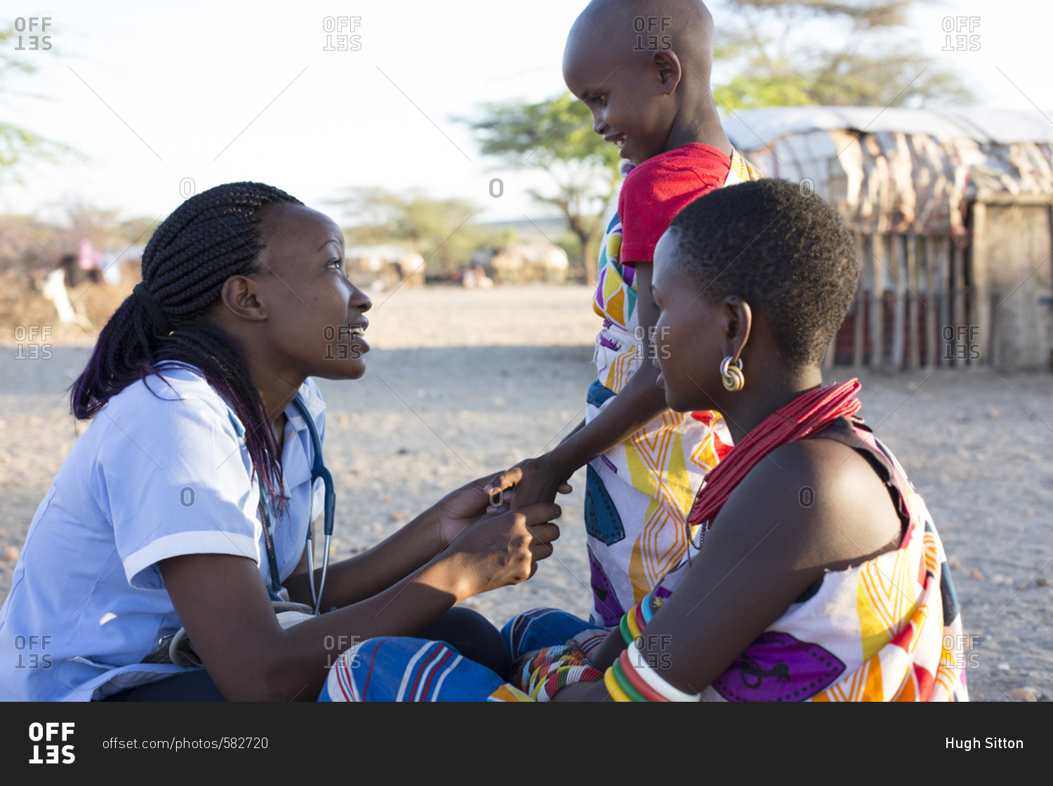 Nurse examining mother and daughter in rural village in Kenya, Africa