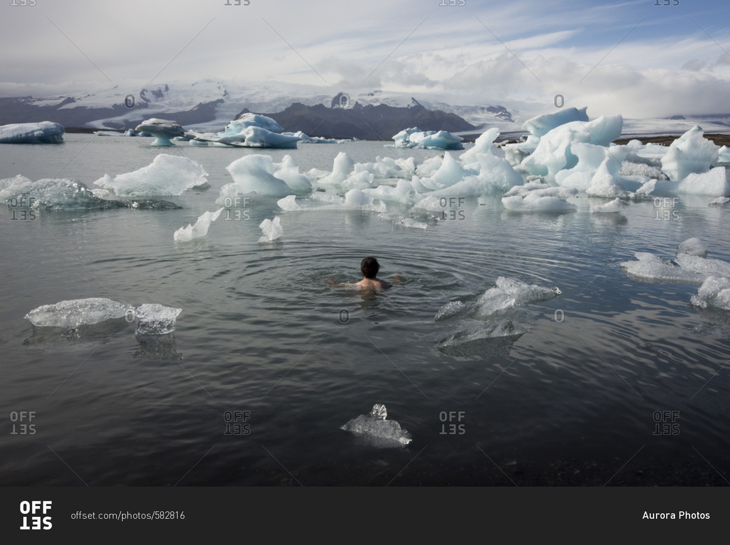 Man Bathing Naked In A Glacier Lagoon Surrounded By Icebergs And 