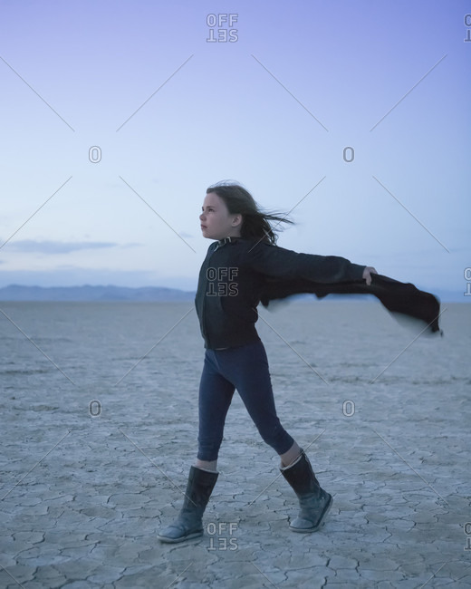 Young girl catching wind in wind in desert