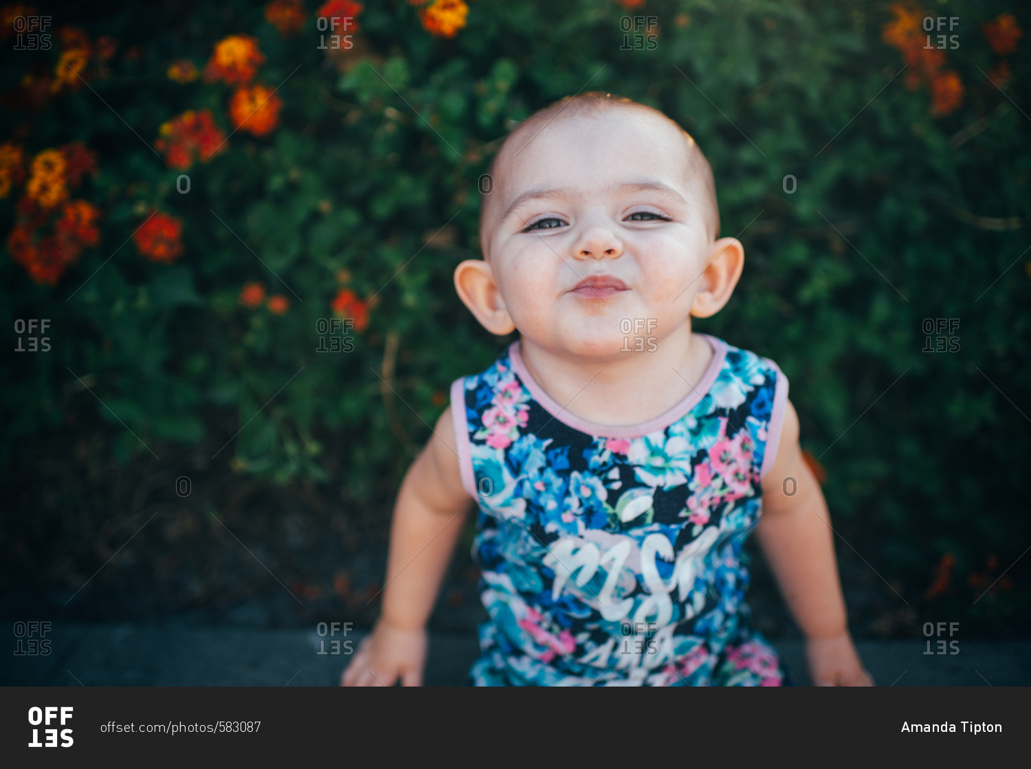 Toddler making smiling face by flowers