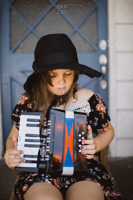 Girl on porch playing accordion