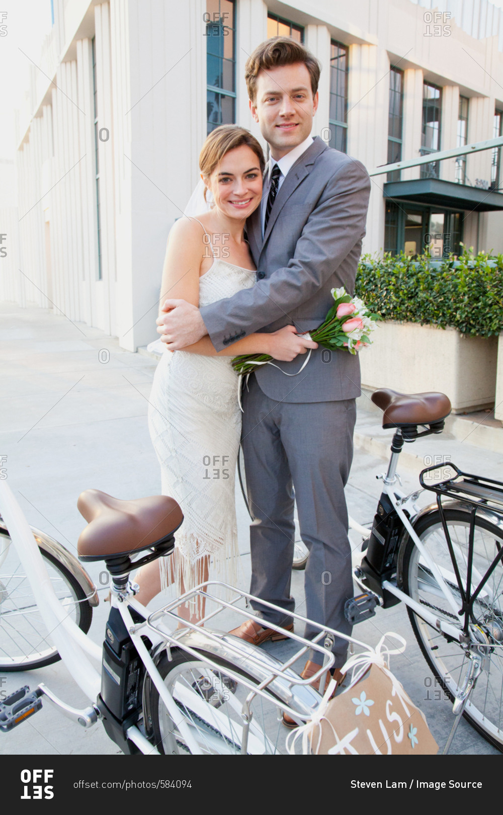 Portrait of young newlywed couple with bicycles