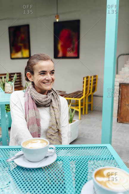 Mid age woman smiling while having a coffee in a coffee shop in Bogota, Colombia