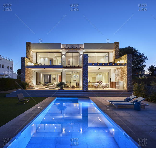 L'Ametlla de Mar, Spain - June 22, 2017: Exterior view of J&P House - White Houses, Port Calafat, Spain Garden facade and swimming pool at dusk