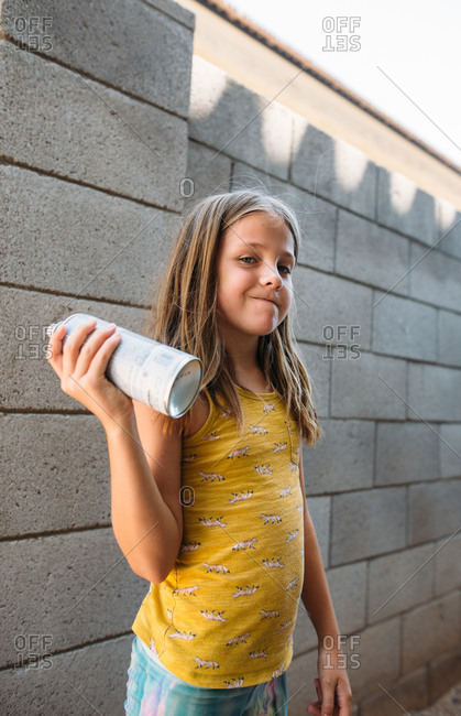 Little girl holding can of spray paint