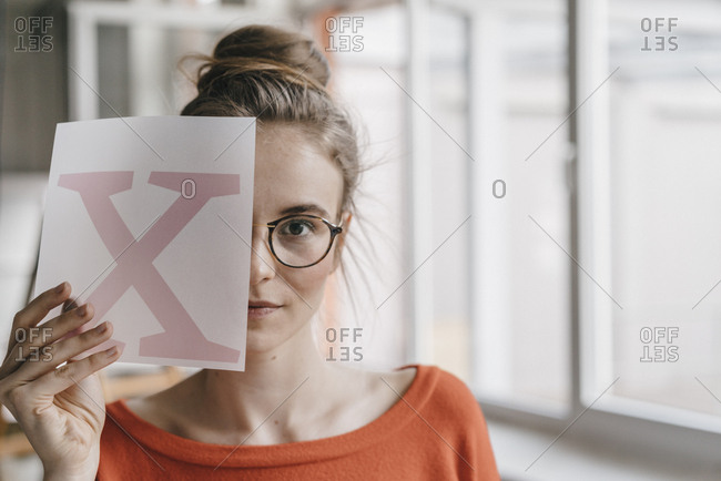 Portrait of young woman holding letter x template