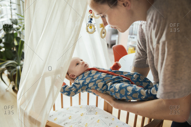 Mother Putting Her Newborn Baby Boy Into Crib Stock Photo Offset