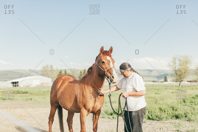 Umatilla Reservation, Pendleton, Oregon - May 10, 2017: Woman petting brown horse