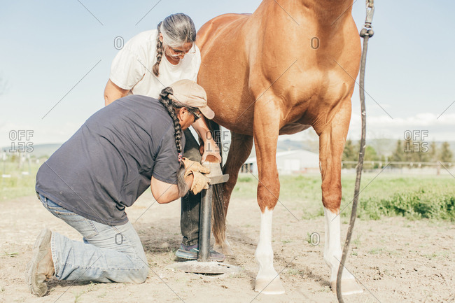 Umatilla Reservation, Pendleton, Oregon - May 10, 2017: Couple filing horse's hooves