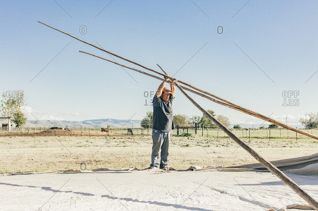 Umatilla Reservation, Pendleton, Oregon - May 18, 2017: Man setting up a tipi