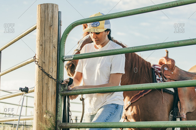 Umatilla Reservation, Pendleton, Oregon - May 18, 2017: Girl opening horse pen on the Umatilla Reservation in Oregon