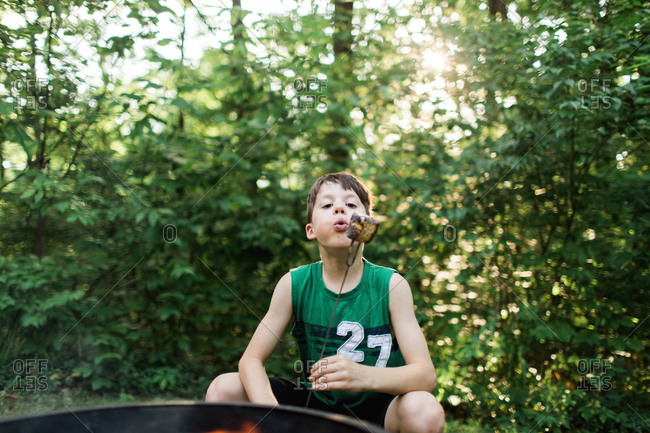 Boy with toasted marshmallow at campfire