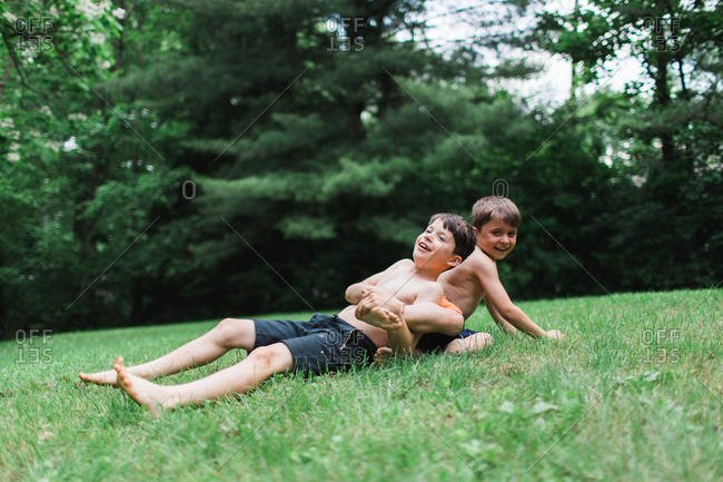 Two brothers wrestling on lawn