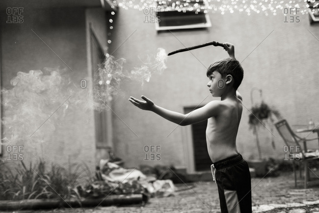 Boy waving a smoking stick