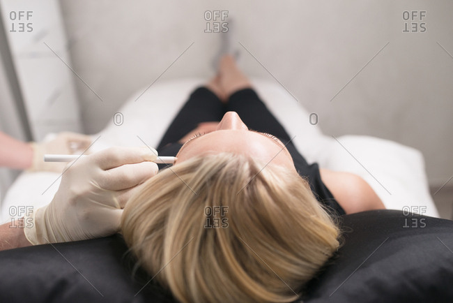 Doctor marking woman's face before an anti-wrinkle injection