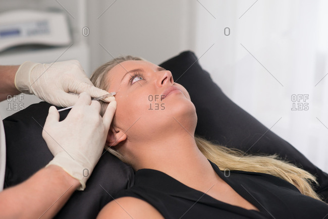 Doctor preparing to inject woman with an anti-wrinkle medicine