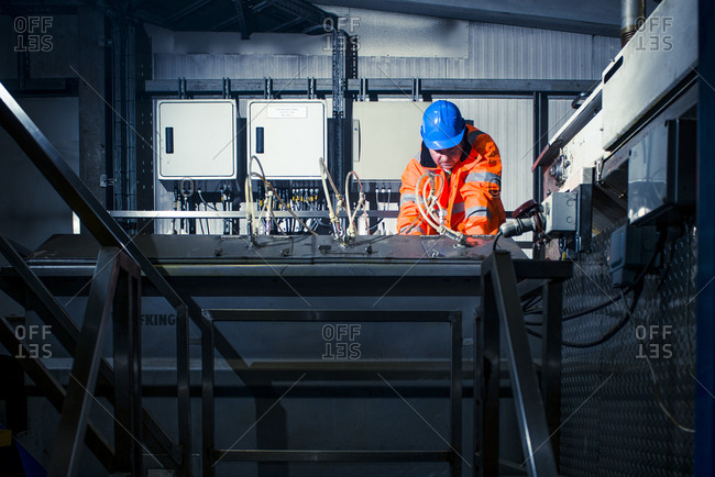 Yorkshire, England, UK - October 29, 2012: Man operating machine in industrial setting