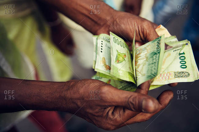 Person holding Sri Lankan money