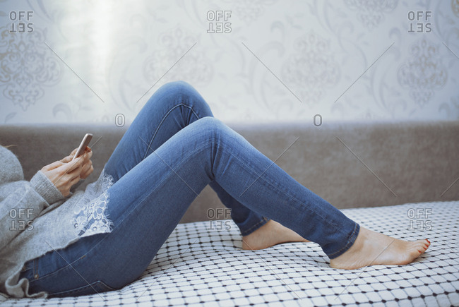 Woman Laying On A Couch And Using A Smartphone Stock Photo Offset