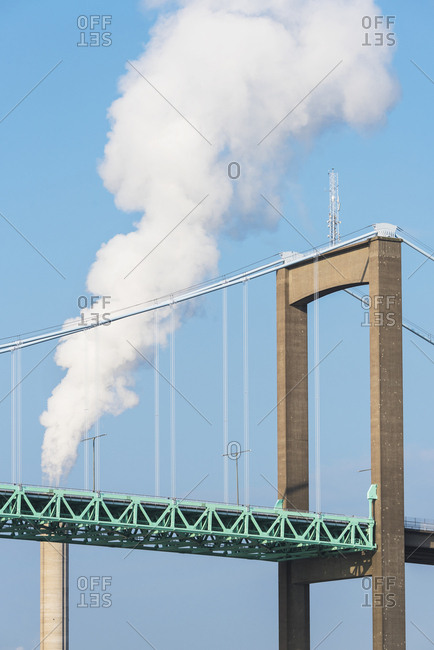Bridge with smoking chimney on background