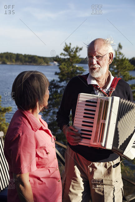 Senior man playing accordion to senior woman