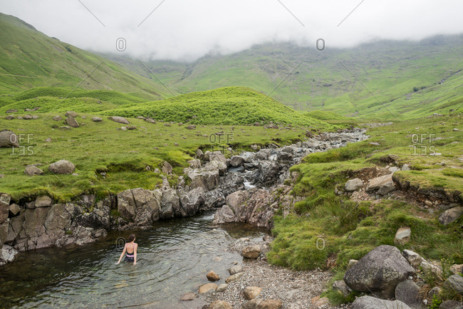 A woman swims in the Langdale Valley in the Lake District