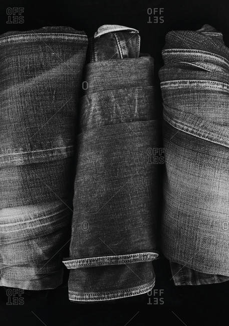 Close-up of three folded pairs of denim jeans