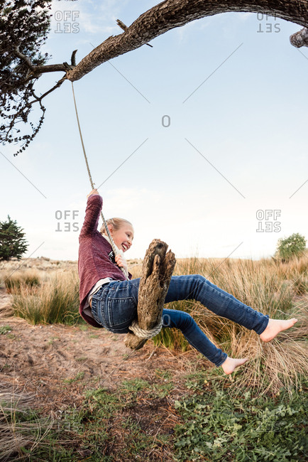Girl having fun on a coastal rope swing