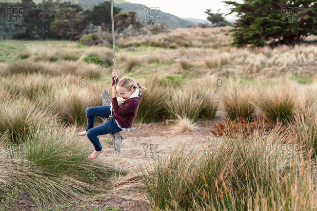 Girl having fun on coastal rope swing