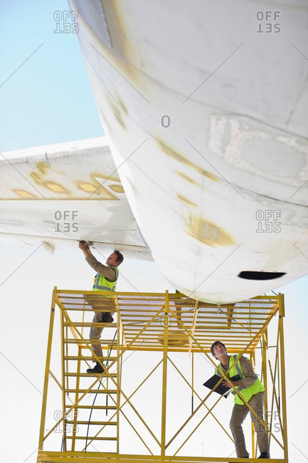 Aircraft workers repairing airplane