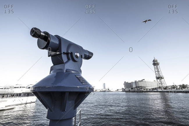 Barcelona, Spain - February 8, 2017: A telescope on the Rambla de Mar, pointed at Port Vell and the Maremagnum shopping mall
