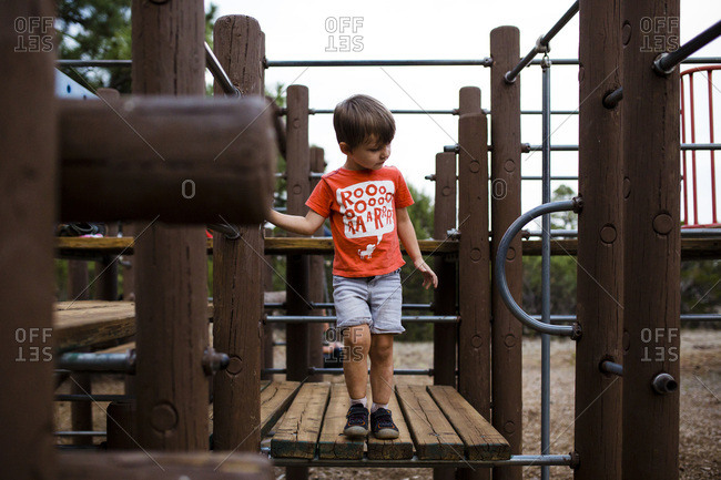 Young boy climbing on playground jungle gym