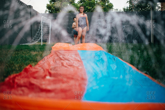 Kids preparing to slide down a backyard water slide