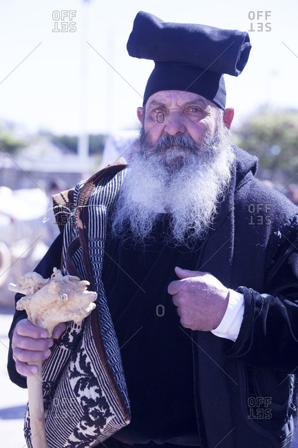 Sardinia, Italy - April 30, 2017: Man wearing the traditional Berritta Sardinian hat and carring the traditional double Sardinian sac, St. Antioco celebrations, Sant'Antioco