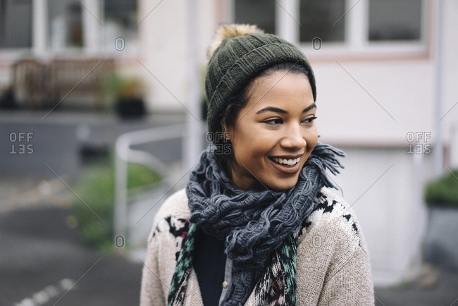 Smiling young woman wearing wooly hat outdoors