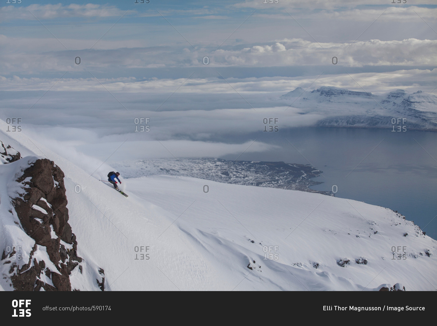 Man snowboarding down mountain at Eskifjordur, Iceland