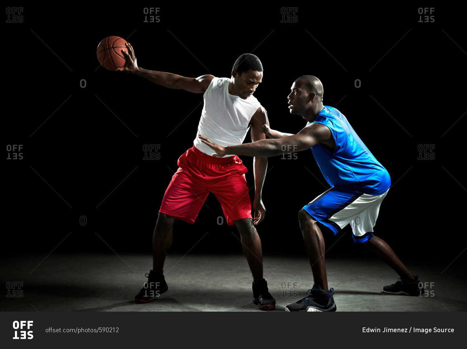 Young male basketball players competing for ball