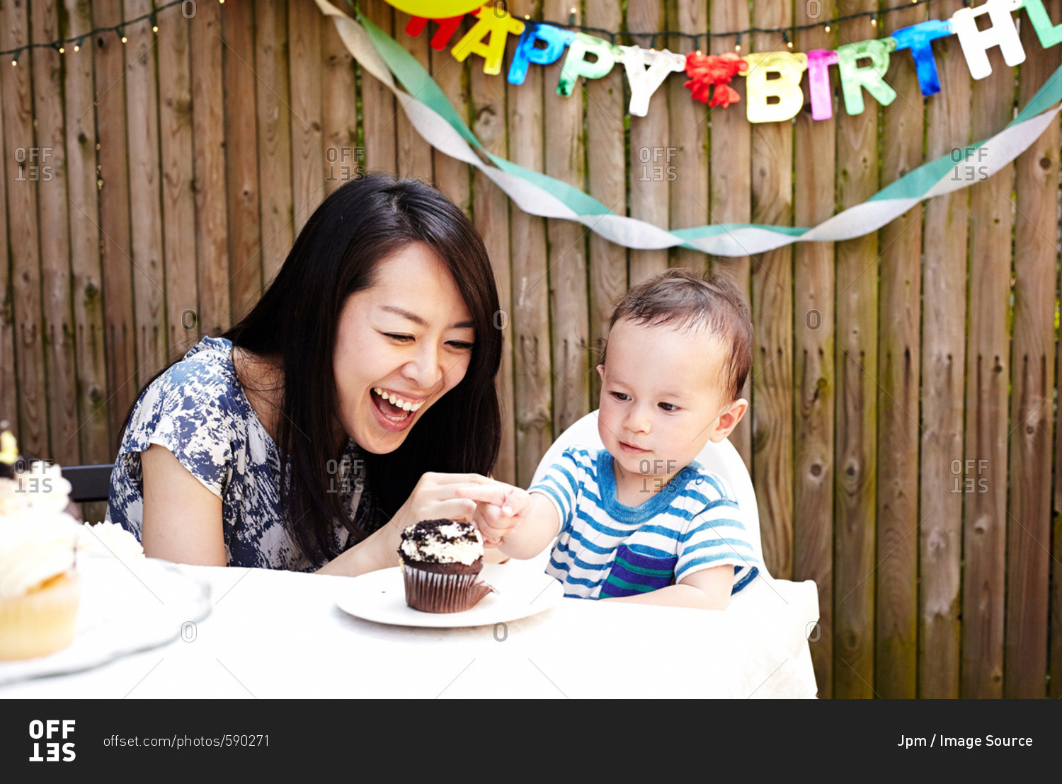 Mother and baby boy smiling with birthday cake