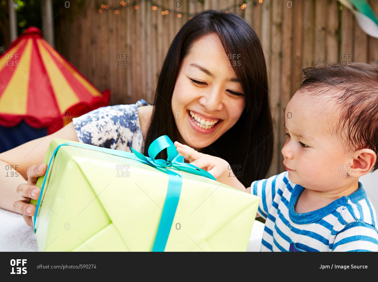 Mother giving baby boy a birthday present
